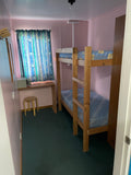 Bunk room at The Adventure Lodge Taranna featuring single beds and comfortable accommodation for divers and groups.