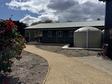 Outside view of The Adventure Lodge Taranna showing the entry path leading to the main lodge building.
