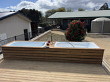 Outdoor gear wash deck at The Adventure Lodge Taranna featuring two bathtubs for rinsing and cleaning dive equipment.